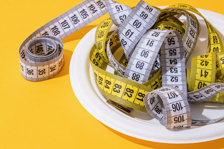 Dieting concept. colorful measuring tapes top view on bright red background, front view