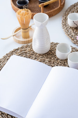 Book mockup design. Blank white book on dining table in Asian style with tableware and napkinsの写真素材