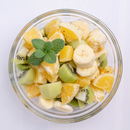 Bowl of healthy fresh fruit salad on white wooden background. Top view.の写真素材