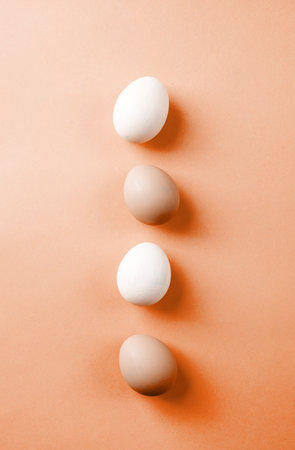 Color of the year 2024: Peach Fuzz. Easter background. Pastel colored easter eggs on blue backgroundの写真素材