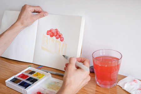 unrecognizable woman drawing watercolor on hotel room tableの写真素材