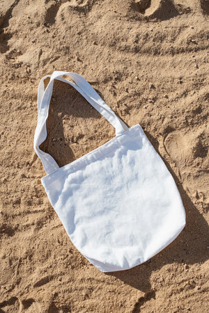 Mockup shopper handbag, beach sand background. Top view copy space shopping eco reusable bag.の写真素材