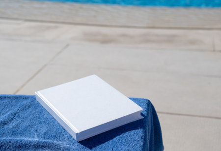reading on vacation. blank book for mockup design on lounger by the swimming poolの写真素材