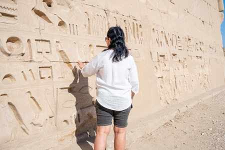 mature adult woman traveler explores the ruins of the ancient Karnak temple in the city of Luxor in...