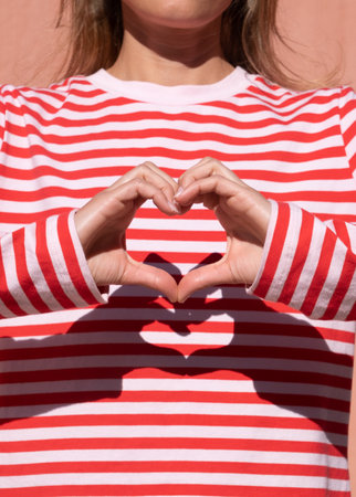 Female hands making sign Heart by fingers. Beautiful hands of woman with copy space. Love concept on Valentine's day.の写真素材