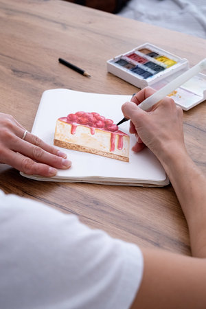 young woman drawing watercolor picture at homeの写真素材