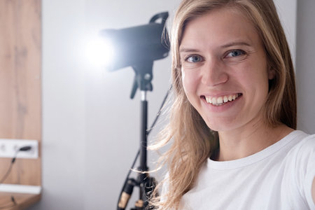 selfie portrait of woman video maker at work, working on content making, using and controlling video...