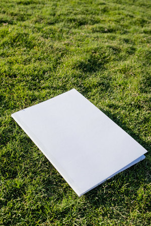 Mockup magazine on green grass background, reading on vacation.の写真素材