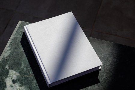 Magazine cover mockup design. blank magazine mockup on green marble stone coffee table, shadow overlay, high contrastの写真素材