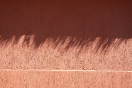 terracotta background textured wall with shadow overlayの写真素材