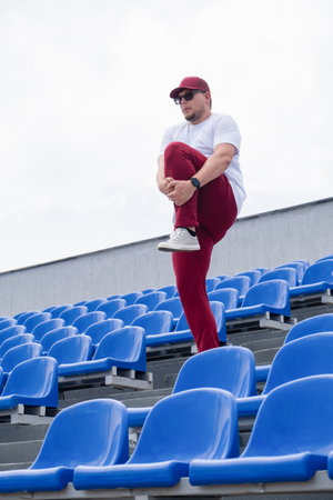 sportsman wearing read and white sport clothes running in the stadium among blue seatsの写真素材