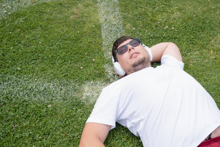 Young man tired during jogging on the track in sport stadium. Young male intense training workout challenge feeling exhaustedの写真素材