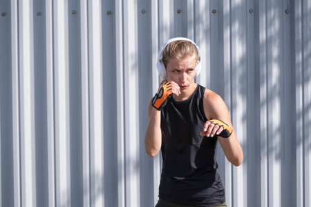 young sportive blond female boxer training in the stadiumの写真素材