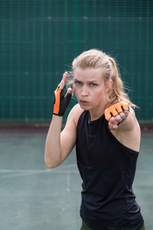 young sportive blond female boxer training, ready to punchの写真素材