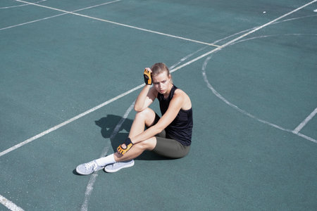 young female boxer training in the stadium, having restの写真素材