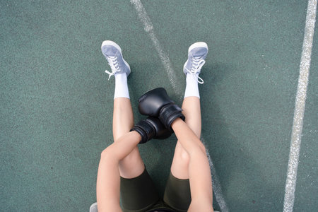 young female boxer training in the stadium, having restの写真素材