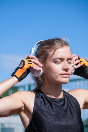 young female boxer training in the stadium, warming up and listening to the musicの写真素材