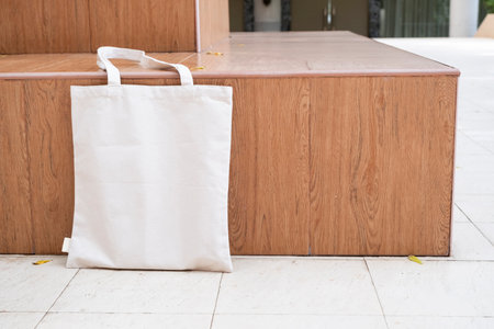 Canvas tote bag on the bench in the park mockup. Rustic linen shopper bag mock up for branding presentationの写真素材