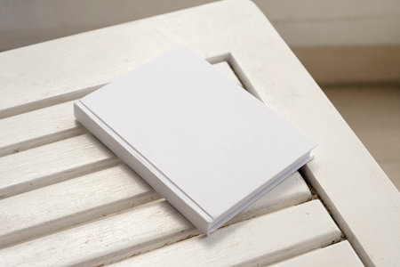 blank book cover for mockup design on wooden outdoor table, hotel balcony or terrace