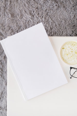 blank magazine mockup on wooden coffee table with green matcha tea near window, Asian styleの写真素材