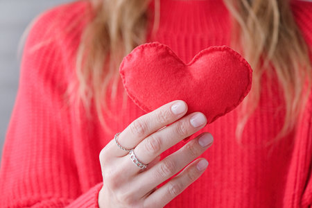 female hands holding red heart shape