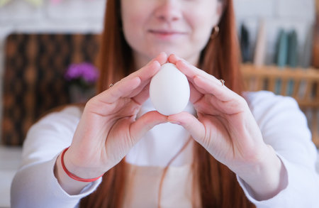 Easter Family traditions. woman holding white easter egg, getting ready for Easter. easter egg...