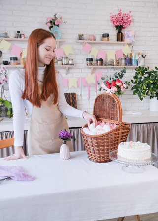 Easter Family traditions. woman in apron putting the white eggs into the basket, getting ready for Easterの写真素材