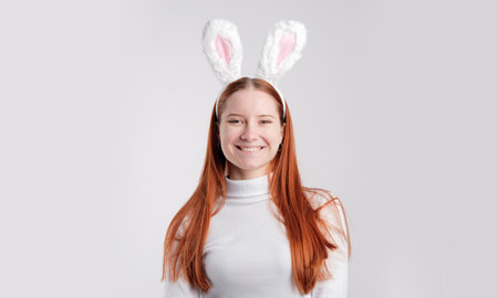 Lifestyle Happy Easter concept. Smiling woman wearing rabbit ears isolated over light white color backgroundの写真素材