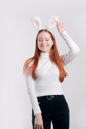 Lifestyle Happy Easter concept. Smiling woman wearing rabbit ears, isolated over light gray color backgroundの写真素材