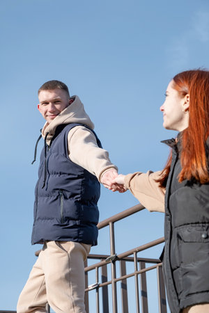Outdoor photo of happy young woman enjoying date. cheerful romantic couple dating and holding hands...