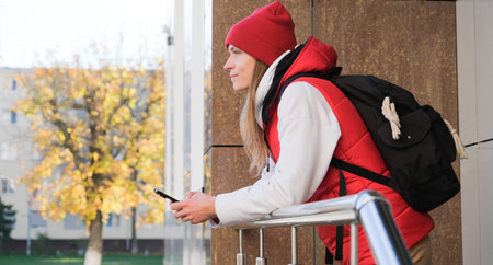 sportive Caucasian woman texting using smartphone in the street and laughing