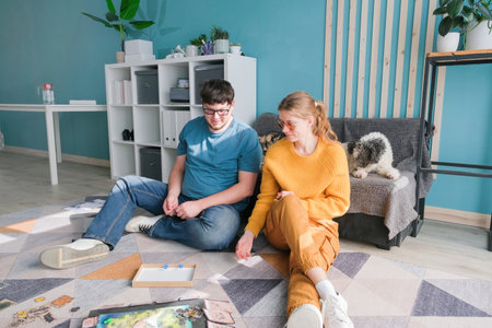 Beautiful young couple having fun playing board game while relaxing and enjoying leisure time...