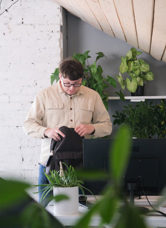 millennial man in stylish casual clothes using headphones and computer while spending time at home