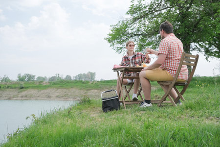 Family on picnic near the lake, picnic table and cooler boxの写真素材