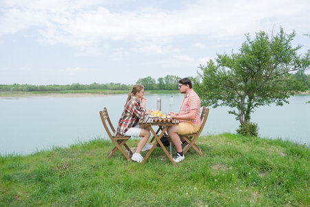 Family on picnic near the lake, picnic table and cooler boxの写真素材