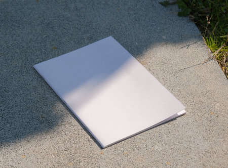 empty magazine mockup on concrete stone floor or pavement outdoors, shadow overlay. For advertising, brand design, stationery presentationの写真素材