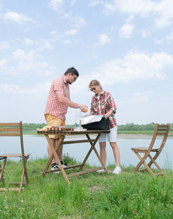 Family on picnic near the lake, picnic table and cooler boxの写真素材