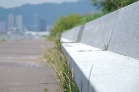 concrete bench with grass and blurred maritime port in Kobe, Hyogo in Japan