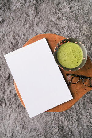 blank magazine mockup on wooden coffee table with green matcha tea and glassesの写真素材