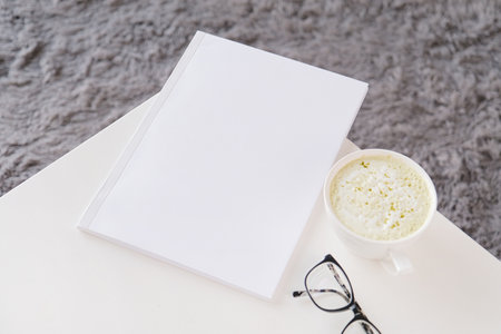 blank magazine mockup on wooden coffee table with green matcha tea near window