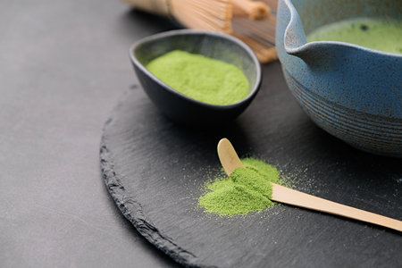 Traditional japanese green matcha kit, beverage on slate plate, dark background with copy space