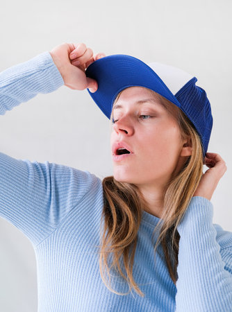 young woman in blue shirt and cap
