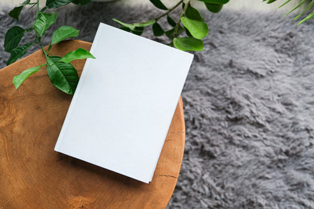 blank book mockup on decorative table with many green plants and gray rug on the floor. Template...