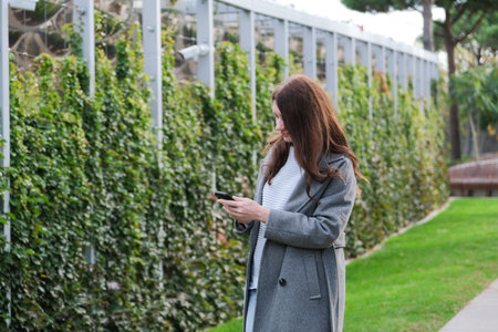 Outdoor, woman and smartphone with connection, typing and happiness with social media, nature and...