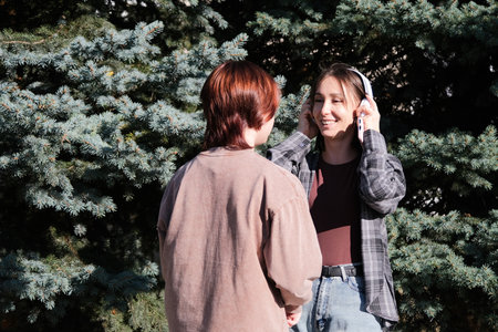 mother and teen daughter listening to music outdoorsの写真素材