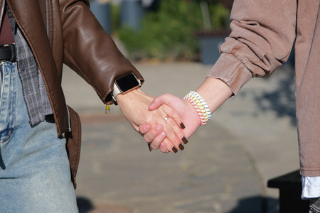 mother and teen girl holding hands in the street, closeupの写真素材