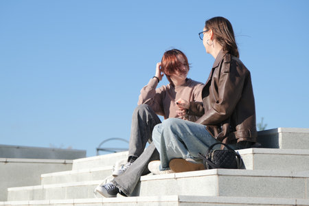 teen girl and mother sitting on the stairs huggingの写真素材
