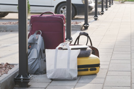 pile of suitcases and bags on parking lot near car. Concept of travel and transportationの写真素材