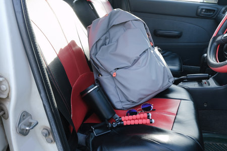 red and black car Interior with backpack, coffee cup, tripod and sunglassesの写真素材