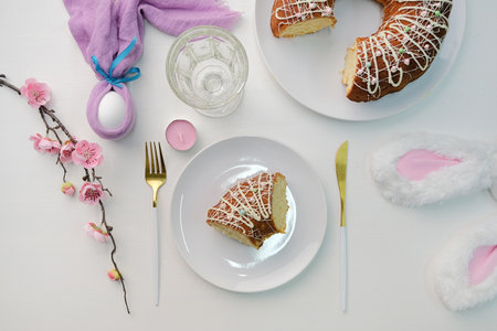top view Easter table setting, glazed Easter cake and candles on table decorated for Easter
